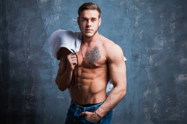 Stüdyoda seksi kaslı erkek modeli. Genç budybuilder uygun güçlü sportif adam kameraya poz. Çıplak gövdeli adam.
