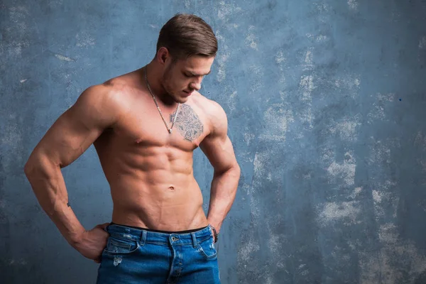 Stüdyoda seksi kaslı erkek modeli. Genç budybuilder uygun güçlü sportif adam kameraya poz. Çıplak gövdeli adam.
