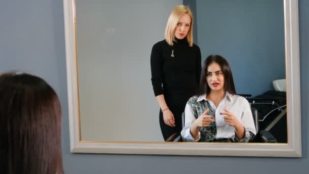 Приваблива брюнетка в салоні краси для волосся консультування з майстром перукарні — стокове відео