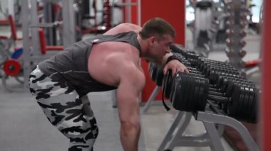 Erkek vücut geliştirmeci spor salonunda ağır halter kaldırma.