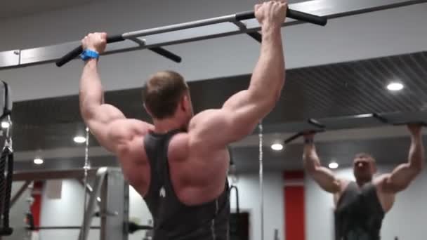 Fit muscular man train hard on sports equipment at gym, chin-ups — Stock Video