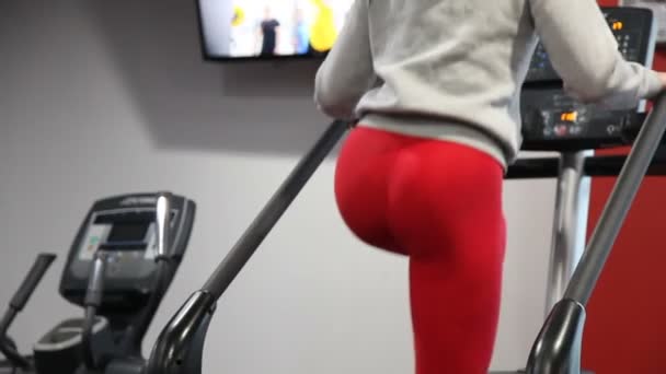 Fit smal kvinna med stor form gör Cardio på fitnessutrustning — Stockvideo