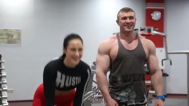 Dos personas en forma levantando pesadas mancuernas y divertirse en el gimnasio . — Vídeos de Stock