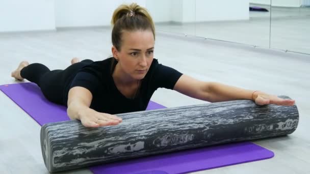 Fit kvinna gör Pilates Rehab övningar med rulle och yogamatta. — Stockvideo