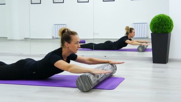 Fit kvinna gör Pilates Rehab övningar med rulle och yogamatta. — Stockvideo