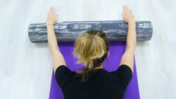 Fit vrouw doen Pilates rehab oefeningen met roller en yoga mat. — Stockvideo