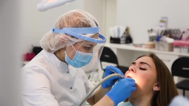 Odontóloga joven curando la cavidad dental . — Vídeos de Stock