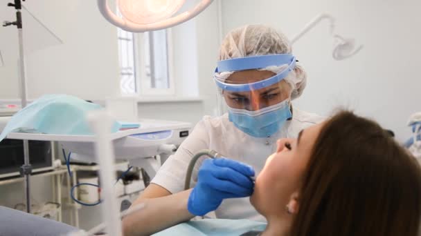 Mladá zubařka vyléčení zubní dutiny a mluvit s pacientem s caries. — Stock video