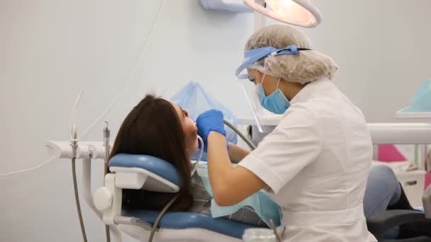 Young female dentist curing tooth cavity. — Stock Video