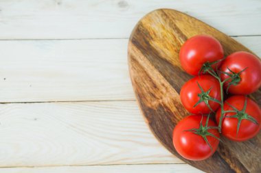 Tahta tabakta taze sulu domates dalı.