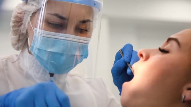 Close-up of concentrated female dentist curing tooth ache, plague and cavity. — Stok Video