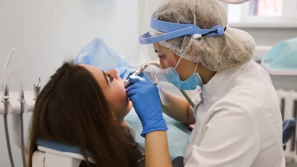 Dentista femenina en máscara de protección cura la cavidad dental . — Vídeos de Stock