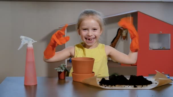 Adorable petite fille placer la plante succulente dans un plus grand pot de fleurs. — Video