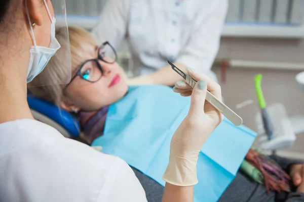 Kobieta stomatolog gotowy do zabiegu stomatologicznego, trzymając skalpel — Zdjęcie stockowe