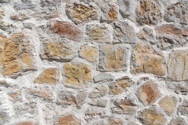 Sarı taşlardan oluşan açık duvar. Duvar kaba yontulmuş kayalardan yapılmıştır.