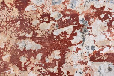 Çatlaklar ve tuğla-kırmızı boya lekeleri ile eski dokulu bir duvar. Terk edilmiş bir evin duvarının yüzeyi.