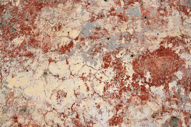 Çatlaklar ve tuğla-kırmızı boya lekeleri ile eski dokulu bir duvar. Terk edilmiş bir evin duvarının yüzeyi.