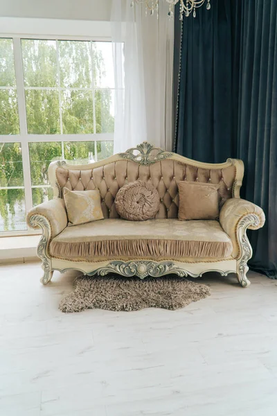 beautiful expensive beige sofa against a white wall in an empty room