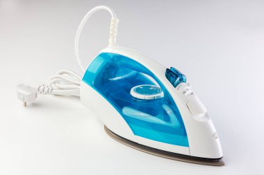 Elektrikli ütü beyaz arka planda duruyor. Metnin ya da imzan için boş yer var.