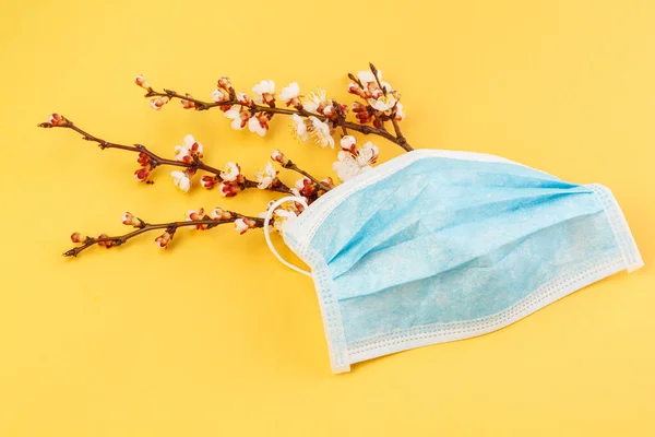 The concept of comparing prevention and health with spring in nature. Means of preventing viral diseases. Medical mask gloves on a yellow background.  Corona virus.
