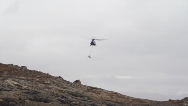Вертолет MI8 перевозит груз на стропе — стоковое видео
