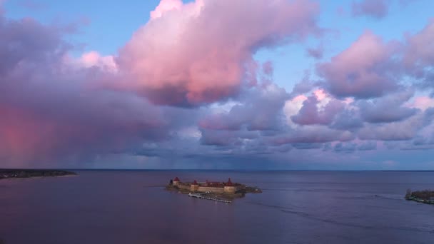 Крепость на воде на закате с красивыми розовыми облаками — стоковое видео