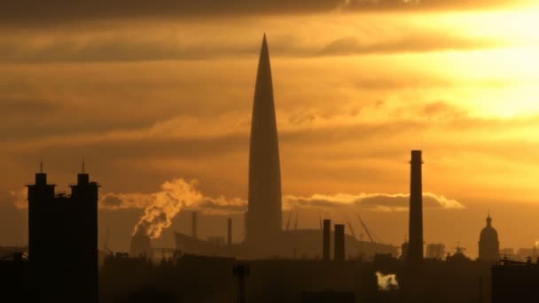 Rascacielos en el fondo de una ciudad industrial con tuberías en la silueta naranja del atardecer — Vídeos de Stock