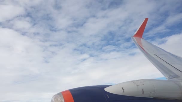 Vista del ala y la turbina de un avión que gira, visualmente parece como si el avión está cayendo. Nubes blancas vuelan rápido en el fondo — Vídeos de Stock