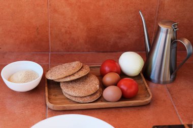 Kalamar yapılan burger için malzemeler. Burger buns, domates, soğan, yumurta, ekmek scrumbles mutfak masasında düzenlenmiş.