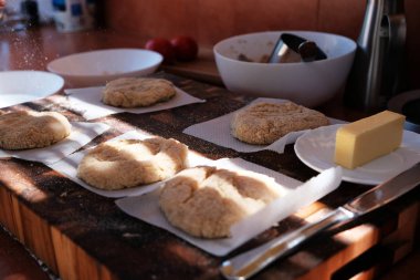 Hamburger için kalamar pirzola hazırlanması. Ekmek kırıntıları ve ahşap mutfak masasında tereyağı. Malzemeler.