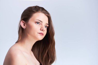 Şehvetli olan kadın gözleri iri ve doğal makyaj ışık gri arka plan üzerinde izole mesafe içine arıyorum. Güzellik ve cilt bakım kavramı. Kopya alanı.