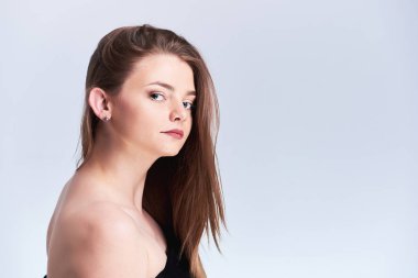 Genç kadın büyük gözleri ve doğal makyaj ışık gri arka plan üzerinde izole kamera bakarak çok. Güzellik ve cilt bakım kavramı. Kopya alanı.