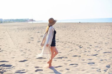 Gülümseyen ve güneşli yaz günü sahilde zevk hasır şapkalı güzel ve genç birbayan. Uzay kopyalayın. Seyahat ve tatil kavramı.