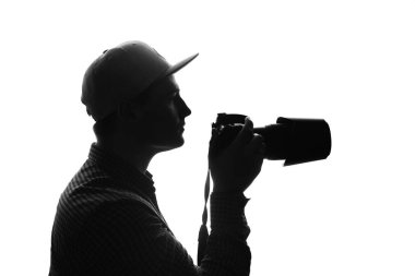 Kamera ve büyük lens ile iş yerinde fotoğrafçı. Tek renkli. Siyah ve beyaz.