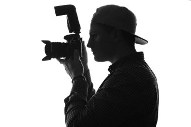 Kamera ve büyük lens ile iş yerinde fotoğrafçı. Tek renkli. Siyah ve beyaz.