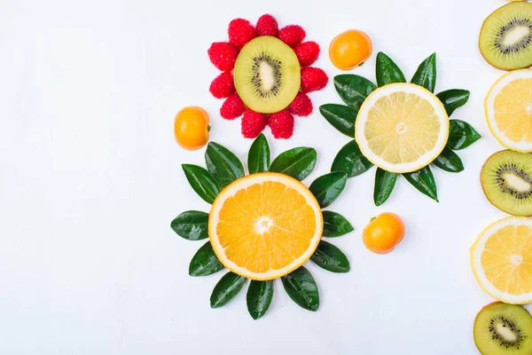 用白色的柑橘果实制成的花朵 猕猴桃 橘子和覆盆子 色彩鲜艳 构图新颖 — 图库照片