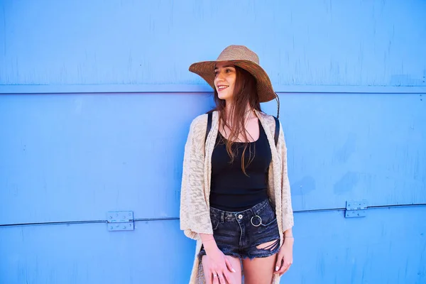 年轻漂亮的女人穿着时髦的草帽微笑着 享受她的假期在阳光明媚的夏日 蓝色背景 — 图库照片