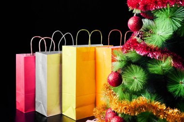 Birçok renkli hediyeler ve Noel ağacı siyah arka plan üzerine izole. Alışveriş ve tatil indirimler.