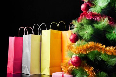 Birçok renkli hediyeler ve Noel ağacı siyah arka plan üzerine izole. Alışveriş ve tatil indirimler.
