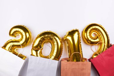 Beyaz arka plan üzerinde izole renkli alışveriş torbasında altın Noel 2019 Sisme Balonlar. Yeni yıl kutlama.