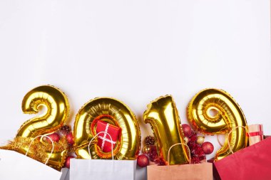 Altın renkli alışveriş torbaları ve beyaz arka plan üzerinde izole hediyeler ile yeni yıl 2019 Sisme Balonlar. Noel kutlamaları ve tatil indirimler.
