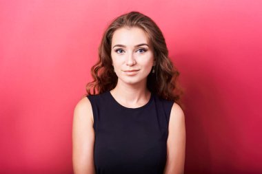 Kırmızı zemin üzerine esmer kıvırcık saçlı Genç Sevimli çekici kız portresi stüdyo.