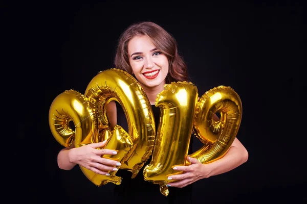 年轻的微笑的女孩与明亮的化妆有乐趣与黄金2019年气球在手在黑色背景 圣诞节和新年庆祝活动 — 图库照片