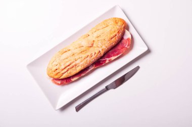 Beyaz kağıt üzerinde izole gevrek baget ve jambon Iberico, lezzetli sandviç yaptım. İspanyol bocadillo.