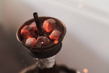 Nargilenin kırmızı sıcak kömürlerle yakın çekimi. Nefes inden kıvılcımlar. Hindistan cevizi kömür ve nargile duman ile Modern nargile.