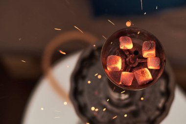 Nargilenin kırmızı sıcak kömürlerle yakın çekimi. Nefes inden kıvılcımlar. Hindistan cevizi kömür ve nargile duman ile Modern nargile.