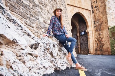 Eski şehirde yürüyüş eski fotoğraf makinesi ile şapkalı güzel genç mutlu kadın. Seyahat ve Turizm kavramı.