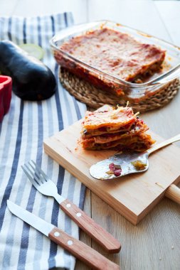 Ev yapımı vejetaryen lazanya sos beşamel ahşap masa üzerinde patlıcan ve domates,.