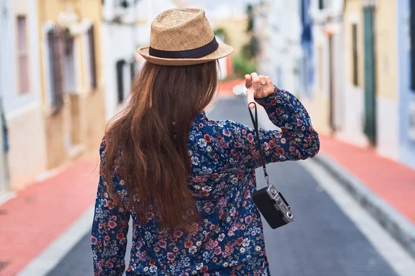 小さなカラフルな建物と通りを歩いて帽子の若い髪の長い女の背面図 — ストック写真