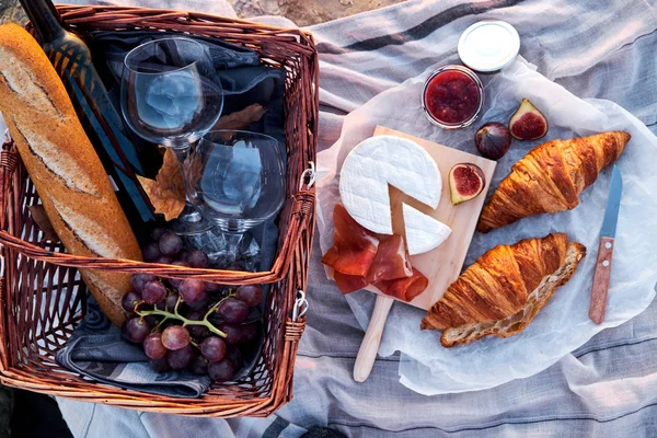 stock image Top view of beautiful romantic picnic composition with croissants, bread, jam, cheese, figs and jamon.